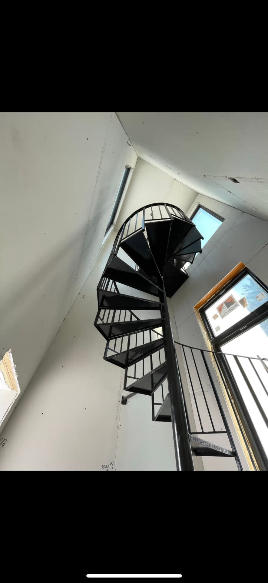 Two-story stairwell drywall finished around a spiral staircase in Londonderry, NH
