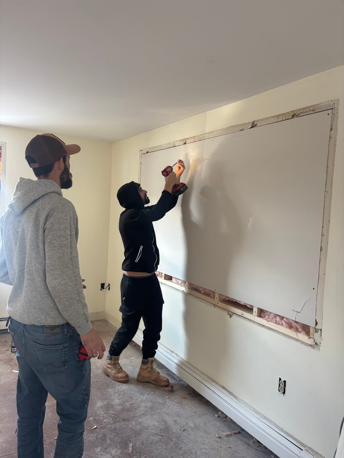 Crew patching a large wall opening during drywall repair in Biddeford, ME