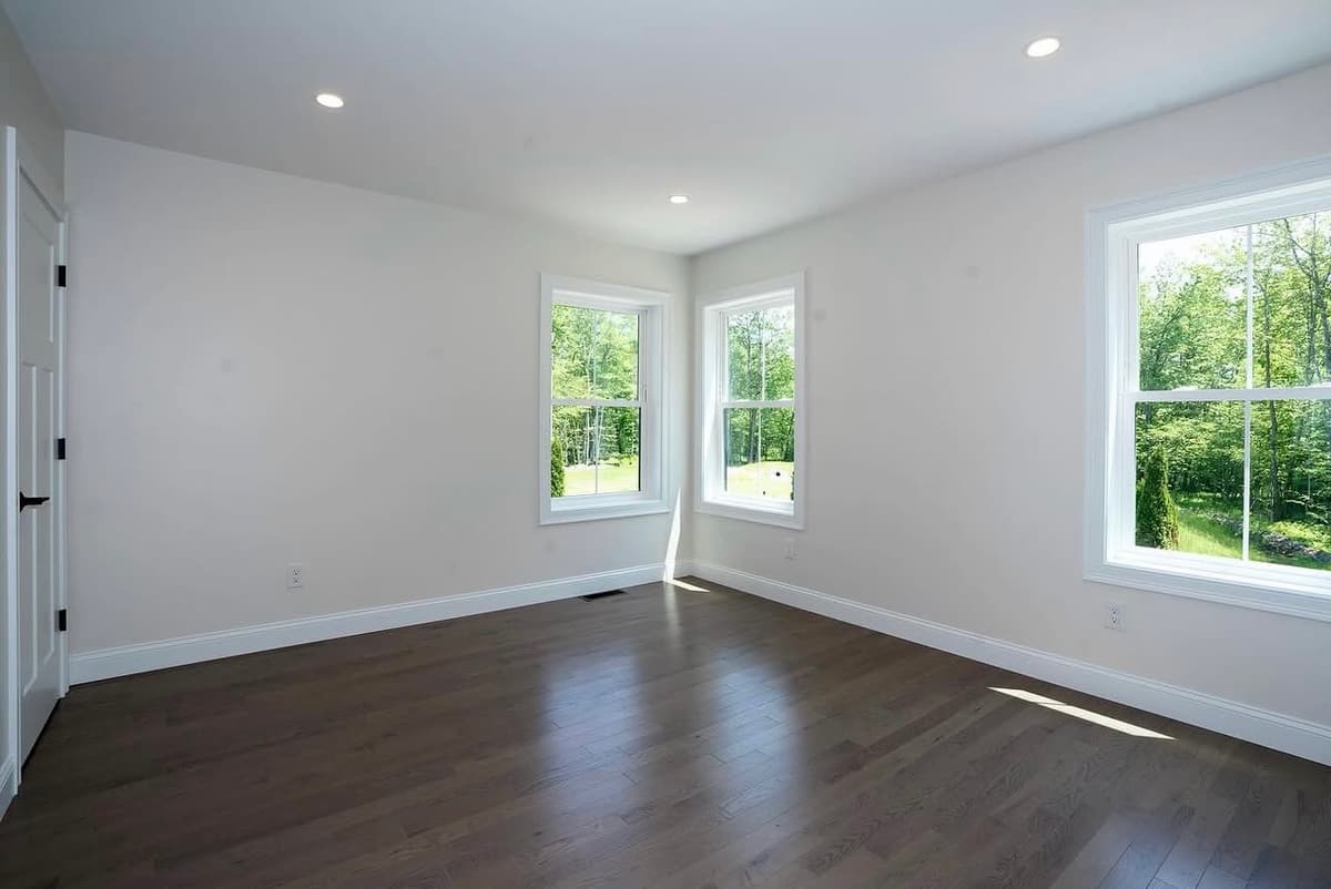 Bedroom with dark hardwood floors after interior painting in Portland, ME